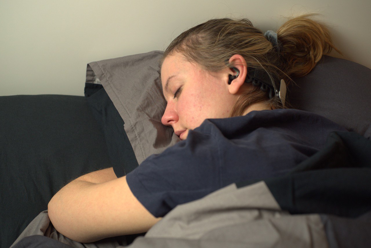 person sleeping wearing the IDUN Guardian in-ear EEG earbuds